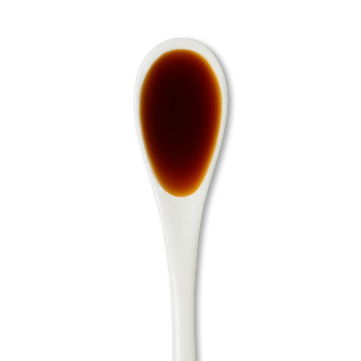A white ceramic spoon filled with dark brown liquid, likely soy sauce, against a plain white background.