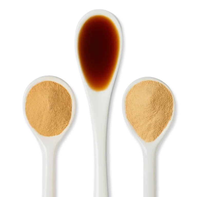 Three white spoons: the middle spoon contains a dark brown liquid, while the two outer spoons hold light brown powder.