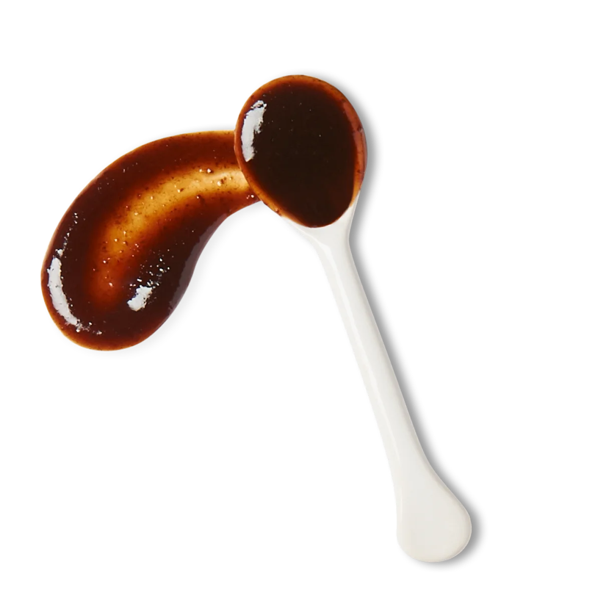 A white spoon with thick, dark brown sauce on it, with some sauce spilled beside the spoon on a white background.