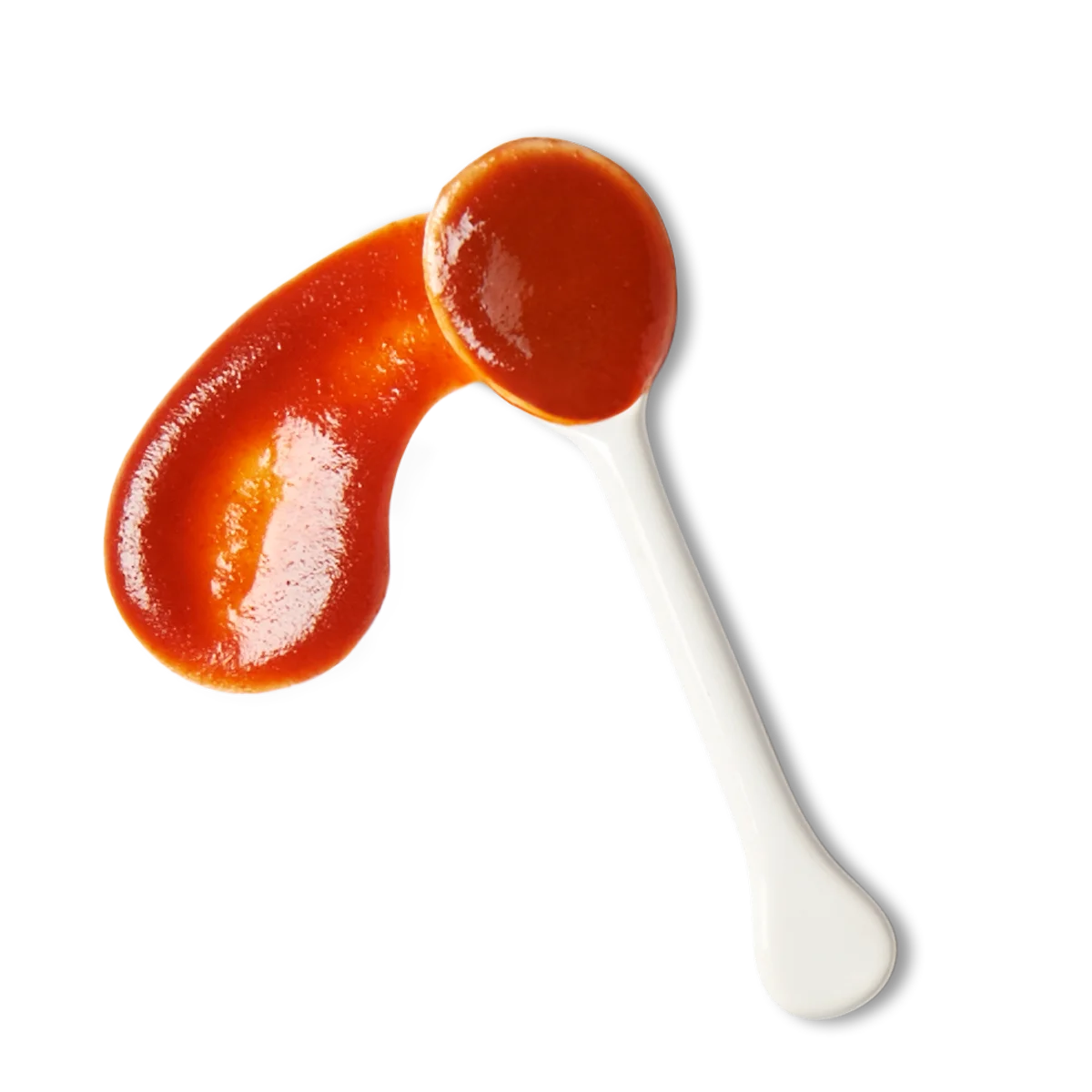 A white spoon with tomato ketchup, some of which is spread in a curved shape next to it.