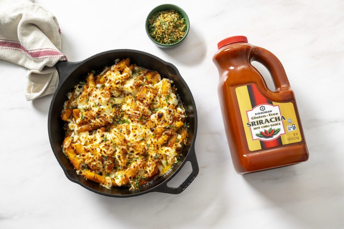 Rice Cakes Al Forno with ’nduja, tomato, and Kikkoman® Gluten-Free Sriracha sauce, topped with melted mozzarella and shallot gremolata.