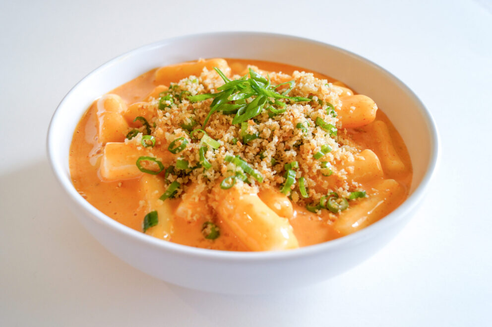 Plant-based Tteokbokki-style kimchi mac and cheese topped with crispy Kikkoman Panko and fried wonton crumbs, garnished with scallions.