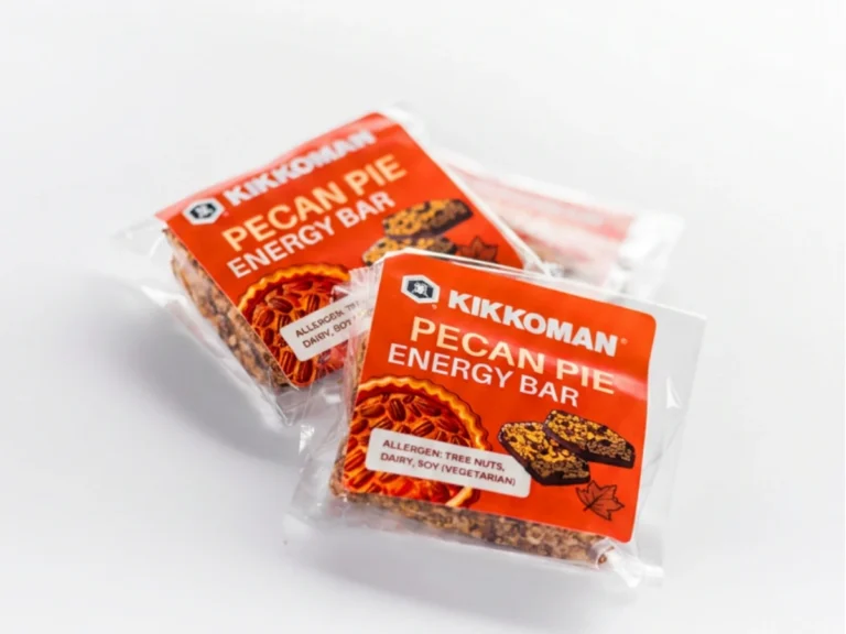 Two individually wrapped Kikkoman pecan pie energy bars with orange labels, featuring images of the bar and a slice of pecan pie.