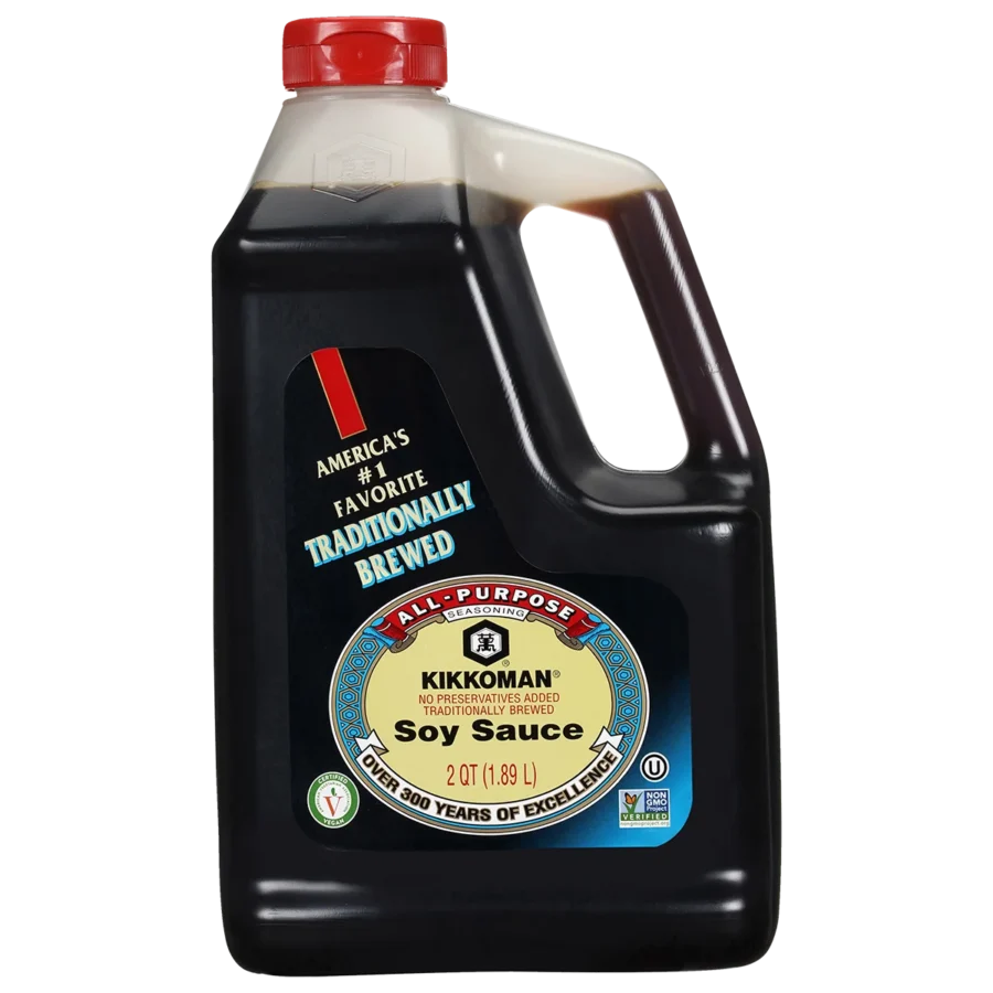 A 64 fl oz plastic jug of Kikkoman all-purpose soy sauce with a red cap and product label stating “Traditionally Brewed” and “No Preservatives Added.”.