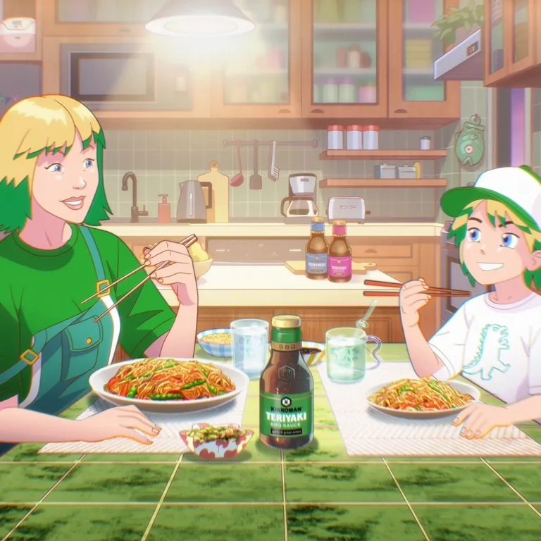 Two people with green hair eat noodles with chopsticks at a kitchen table. Bottles of teriyaki sauce and drinks are on the table; the background shows kitchen shelves and utensils.